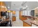 Open-concept kitchen with granite countertops, stainless appliances, and wood cabinetry at 18644 Autumn Lake Blvd, Hudson, FL 34667