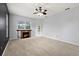 Cozy living room with fireplace, ceiling fan, carpet flooring, and access to outdoor pool at 18644 Autumn Lake Blvd, Hudson, FL 34667