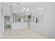 Open-concept space with arches and columns connecting living areas with modern chandeliers and tile floors at 18644 Autumn Lake Blvd, Hudson, FL 34667
