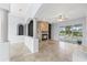 Inviting living room with a stone fireplace, tile floors, and sliding glass doors that lead to a pool at 18644 Autumn Lake Blvd, Hudson, FL 34667