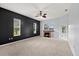 Living room with fireplace, three windows, dark accent wall, carpeted floors and pool access at 18644 Autumn Lake Blvd, Hudson, FL 34667