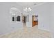 Bright open living area showcases tile floors, columns, views of a stone fireplace and the kitchen at 18644 Autumn Lake Blvd, Hudson, FL 34667