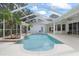 Inviting pool area with a spa, lush landscaping, and a screened-in enclosure at 18644 Autumn Lake Blvd, Hudson, FL 34667