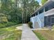Charming exterior of a light blue condo building surrounded by lush greenery at 1983 Abrico Dr # H-9, Lutz, FL 33558