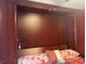 Murphy bed with decorative pillows and a built-in wardrobe providing storage space at 1983 Abrico Dr # H-9, Lutz, FL 33558