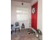 Charming front porch with a bright red door, decorated with a floral wreath and 'Gather' sign at 20720 Eustis Rd, Land O Lakes, FL 34637