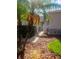 Gated walkway leading to a property, lined with lush landscaping and mulch ground cover at 20720 Eustis Rd, Land O Lakes, FL 34637