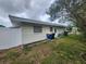 An exterior view of the home's backyard, which features the home's exterior, and foliage at 2083 Envoy Ct, Clearwater, FL 33764