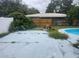 This backyard features a pool, a rock feature, and fencing at 2083 Envoy Ct, Clearwater, FL 33764