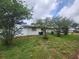 A view of the home's backyard, which features the home's exterior, and foliage at 2083 Envoy Ct, Clearwater, FL 33764