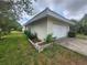 Home featuring an attached garage, lovely backyard lawn, and clean exterior at 2083 Envoy Ct, Clearwater, FL 33764