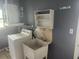 This laundry room includes a utility sink, washing machine, and shelving at 2083 Envoy Ct, Clearwater, FL 33764