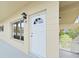 View of front entrance to unit 40 with sconce, white door and railing nearby stairs at 2402 Ecuadorian Way # 40, Clearwater, FL 33763