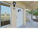 A close-up of the front entrance to unit 40, featuring a white door, sconce, and nearby stairs at 2402 Ecuadorian Way # 40, Clearwater, FL 33763