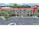 A sunny view of the condo's exterior showing the multiple units with a red roof and well maintained lawns at 2402 Ecuadorian Way # 40, Clearwater, FL 33763