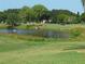 Scenic golf course view with a pond, lush greenery, and distant trees at 2402 Ecuadorian Way # 40, Clearwater, FL 33763