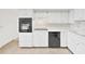 Clean kitchen with white cabinets, black appliances, and tile backsplash at 2402 Ecuadorian Way # 40, Clearwater, FL 33763