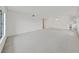 An empty sunlit living room featuring neutral carpet, bright windows and white walls at 2402 Ecuadorian Way # 40, Clearwater, FL 33763