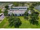 Aerial view showcases condos amidst a green landscape, enhanced by a serene pond and covered parking at 306 Martha Ln # 42, Oldsmar, FL 34677