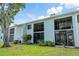 Exterior of a well-kept condo building featuring screened patios and tidy landscaping with a clear blue sky at 306 Martha Ln # 42, Oldsmar, FL 34677