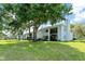 Exterior view showcasing a well-maintained building with lush green lawn and mature trees in a tranquil setting at 306 Martha Ln # 42, Oldsmar, FL 34677