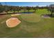 The golf course green features a flag, sand bunkers, and a small pond at 306 Martha Ln # 42, Oldsmar, FL 34677