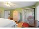 Bedroom with wood floors, a ceiling fan and sliding glass door with patio access at 306 Martha Ln # 42, Oldsmar, FL 34677