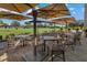 Outdoor seating area with many tables and tan umbrellas on a brick paved patio at 306 Martha Ln # 42, Oldsmar, FL 34677
