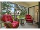 Cozy screened patio with wicker chairs, plush cushions, and views of the landscaped outdoors at 306 Martha Ln # 42, Oldsmar, FL 34677