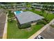 Aerial view of a community pool house featuring a gray roof, landscaping, and palm trees at 306 Martha Ln # 42, Oldsmar, FL 34677