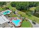 This aerial view showcases two community pools, a pond, a walking path, and a glimpse of the golf course at 3274 Lori Ln # 2, New Port Richey, FL 34655