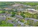 An aerial view features mature trees surrounding the neighborhood with a medical complex in the background at 3274 Lori Ln # 2, New Port Richey, FL 34655