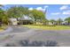 A welcoming clubhouse entrance framed by lush trees and an American flag at 3274 Lori Ln # 2, New Port Richey, FL 34655