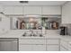 Bright kitchen featuring stainless steel appliances, a double sink, and a mirrored backsplash enhancing the living area view at 3274 Lori Ln # 2, New Port Richey, FL 34655