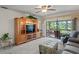Inviting living room with a large entertainment center, comfortable seating, plush carpeting, and a bright sunroom view at 3274 Lori Ln # 2, New Port Richey, FL 34655