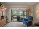 Cozy living room showcasing seating with a view of the screened lanai with beautiful outdoor scenery at 3274 Lori Ln # 2, New Port Richey, FL 34655