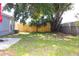 Fenced backyard with mature trees and green grass offers privacy and shade at 3315 W Saint John St, Tampa, FL 33607