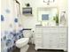 Bright bathroom features a white vanity with drawers, mirror, and blue floral shower curtain at 3315 W Saint John St, Tampa, FL 33607