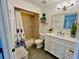 A bright bathroom featuring a walk-in tiled shower, toilet, white vanity and a large framed mirror at 3315 W Saint John St, Tampa, FL 33607