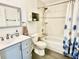 Bright bathroom features a blue vanity, tiled shower, and floral shower curtain at 3315 W Saint John St, Tampa, FL 33607