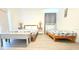 Stylized bedroom with two beds, matching wooden nightstands and lamps and a white cushioned bench at 3315 W Saint John St, Tampa, FL 33607