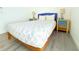 Bedroom with blue headboard, floral quilt, bedside tables, lamps, and wood floor at 3315 W Saint John St, Tampa, FL 33607