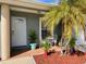Close-up of a front porch with potted plants, seating, and a glass paneled front door at 3315 W Saint John St, Tampa, FL 33607