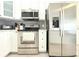 Modern kitchen featuring stainless steel appliances and sleek white cabinetry and light wood floor at 3315 W Saint John St, Tampa, FL 33607