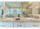 Bright bathroom boasts dual sinks with granite counters, decorative fixtures, and a walk-in shower at 3352 Gulfview Dr, Hernando Beach, FL 34607