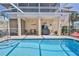 Screened-in pool area with ample seating and an outdoor kitchen, perfect for entertaining guests at 3352 Gulfview Dr, Hernando Beach, FL 34607