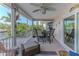 Relaxing screened porch with a ceiling fan, outdoor dining set, and views of the surrounding landscape at 3352 Gulfview Dr, Hernando Beach, FL 34607