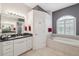 Bathroom featuring double sinks, granite counters, a soaking tub, and a door to the water closet at 3400 Rosebay Ct, Spring Hill, FL 34609