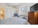 Comfortable bedroom featuring natural light, an inviting blue armchair, and a cozy blue bedspread at 3400 Rosebay Ct, Spring Hill, FL 34609