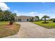 Beautifully landscaped home showcasing a paver driveway, lush lawn, and mature palm tree at 3400 Rosebay Ct, Spring Hill, FL 34609